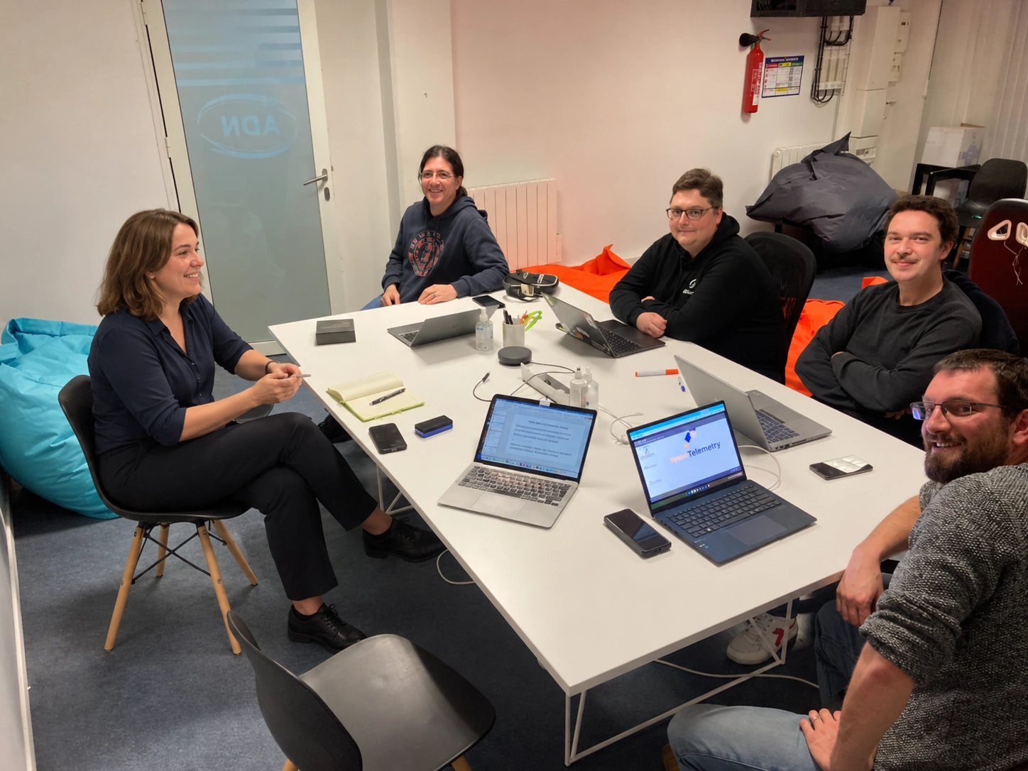 Réunion de travail autour d’une table dans les locaux ADN Consulting — photographie retouchée